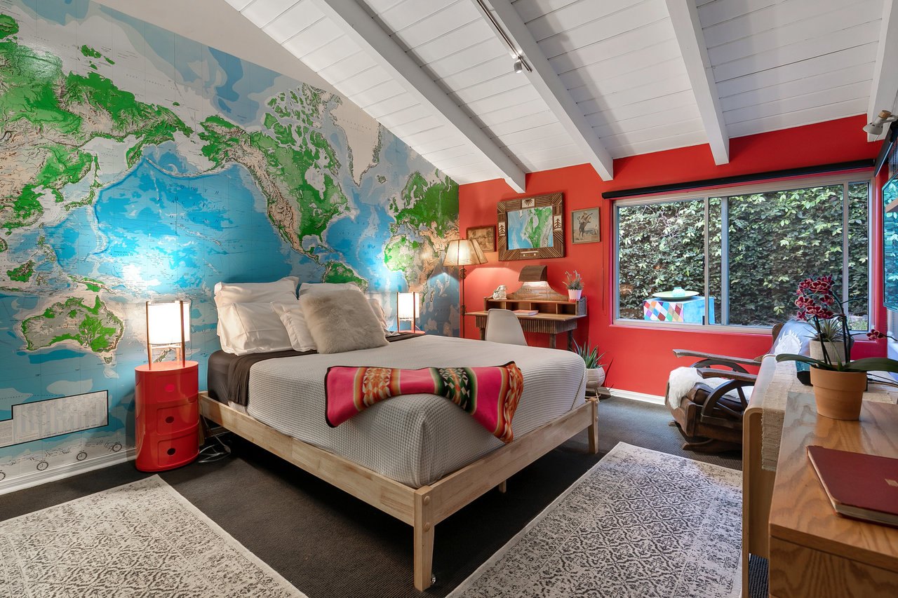 Bedroom three with a world-map mural and garden outlook