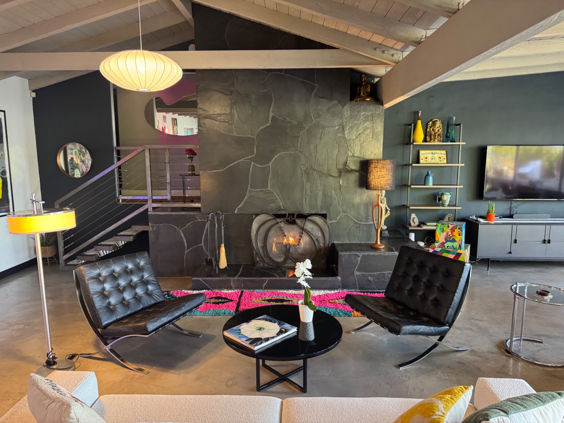 Black lounge chairs beside the slate fireplace