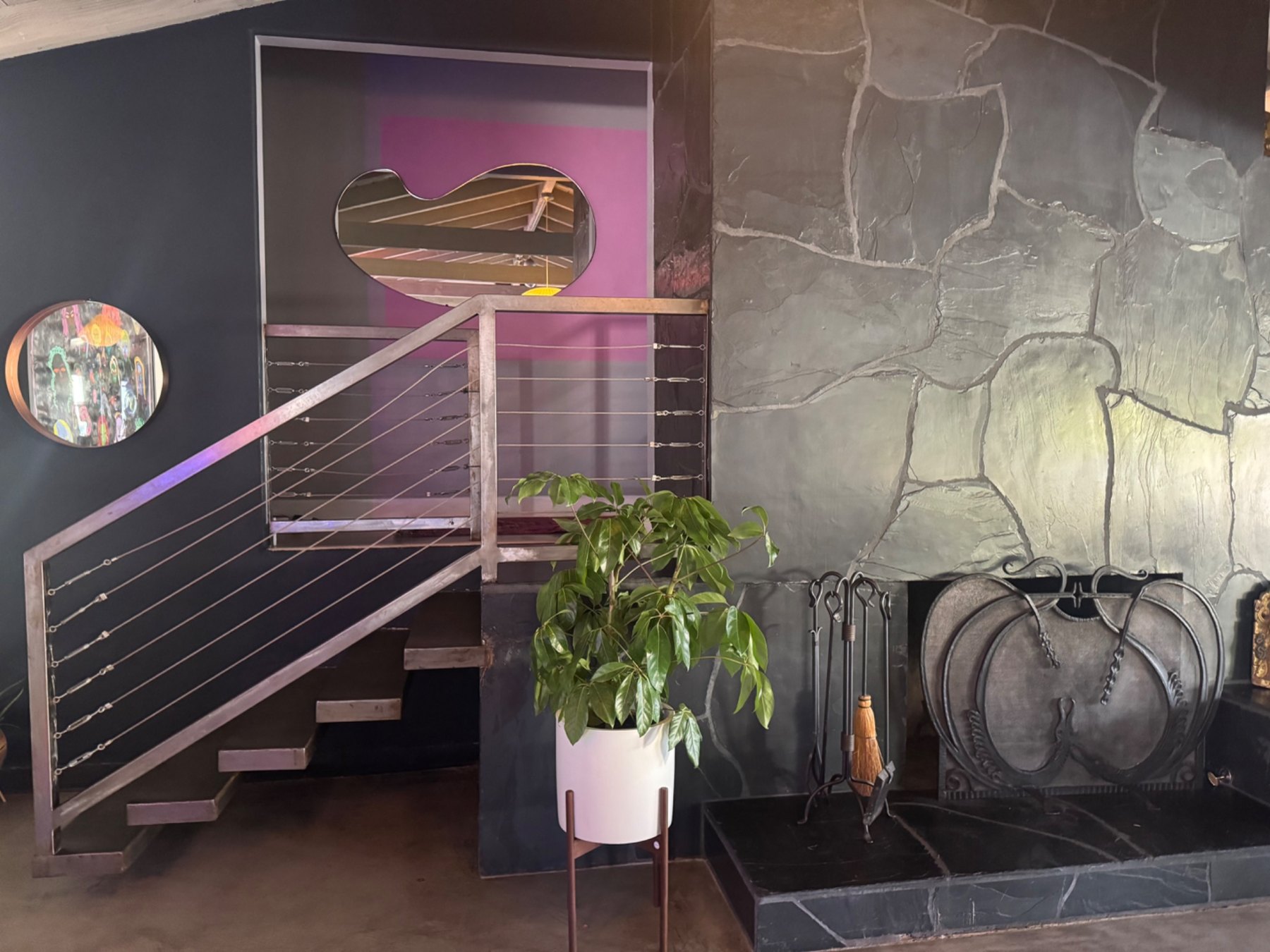 The open staircase beside the slate fireplace