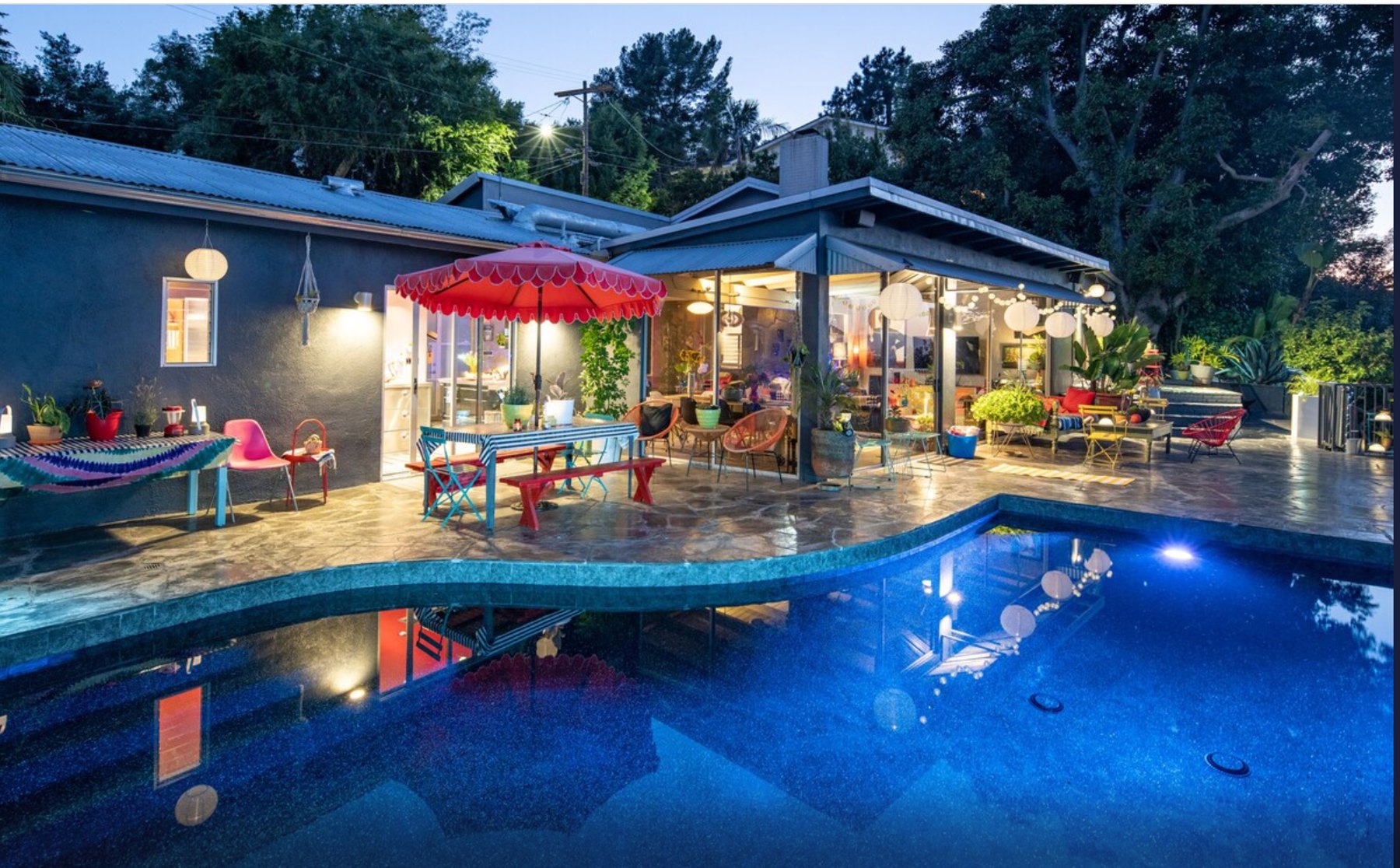 The illuminated pool and house at dusk