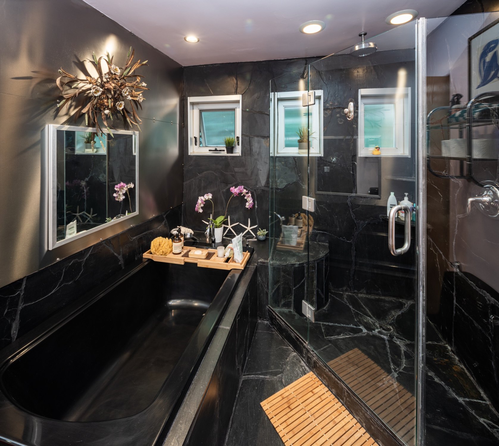 The primary bathroom with dark slate and stainless-steel finishes